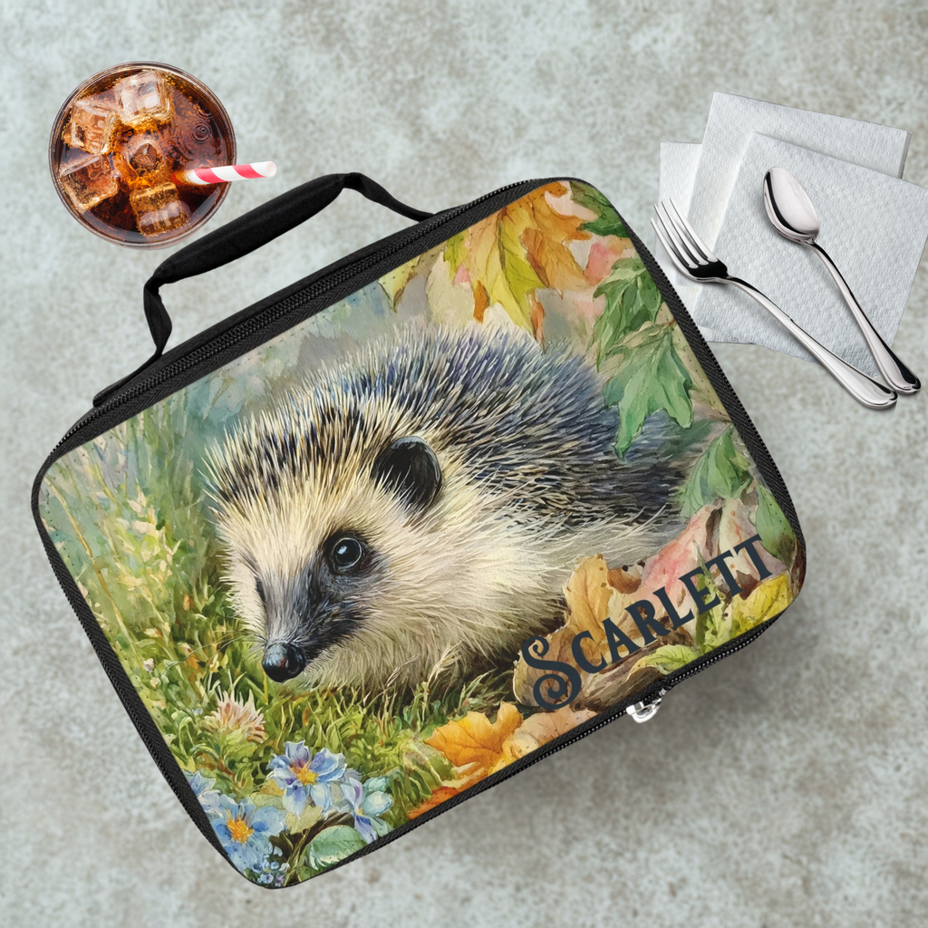 Lunch bag with hedgehog design and 'Scarlett' custom text on a table with a drink and utensils.