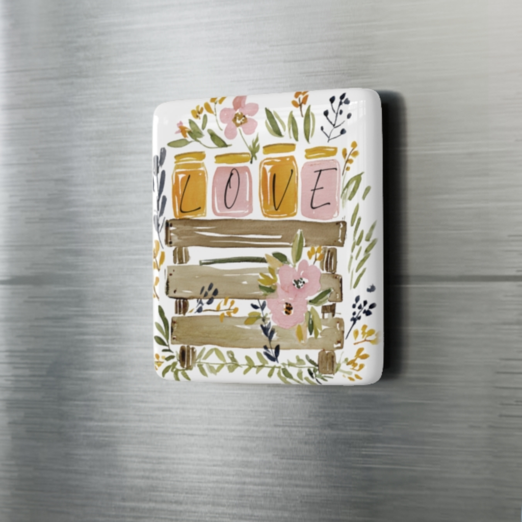 Decorative porcelain magnet with floral design and 'LOVE' text on a metallic surface