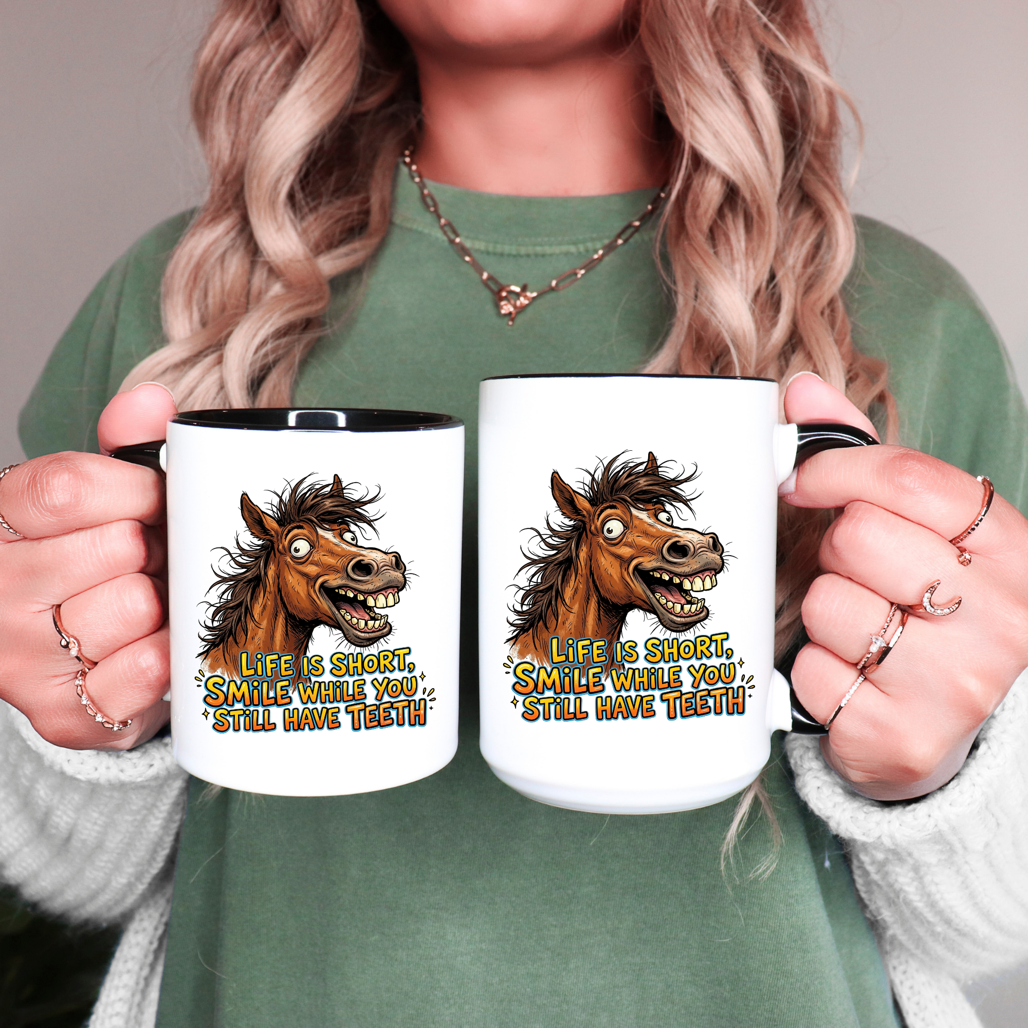 Two black accent mugs with horse illustrations and humorous text held by a person.