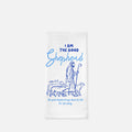 White tea towel with blue illustration of a shepherd and text on a white background