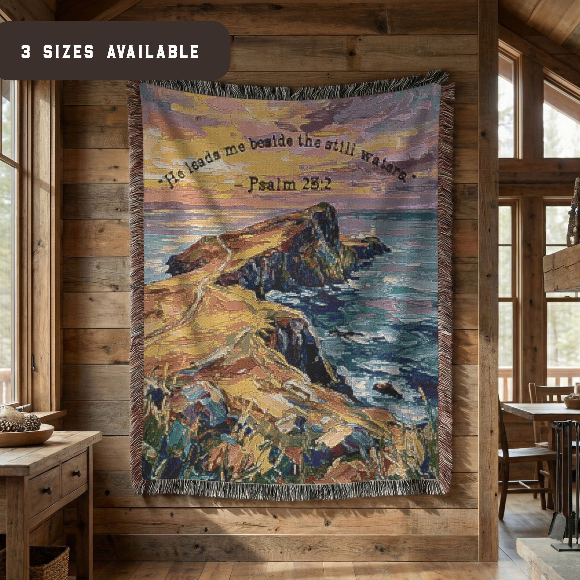 Hanging tapestry woven blanket with a scene of large rocks in the ocean with the tide coming in at sunset and the scripture " He leads me beside the still waters" - Psalm 23:2