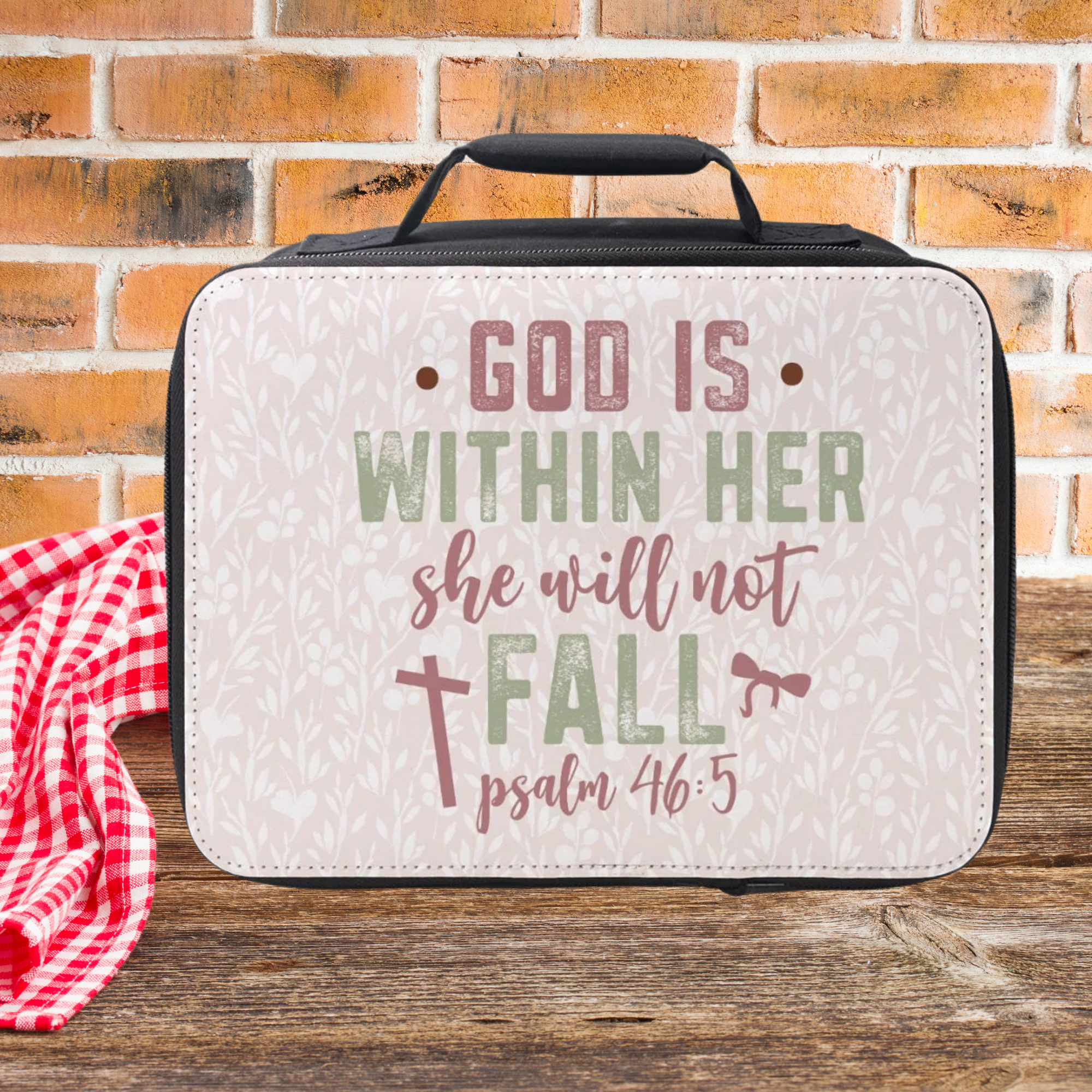  insulated lunch bag with motivational quote on a wooden picnic table with brick background