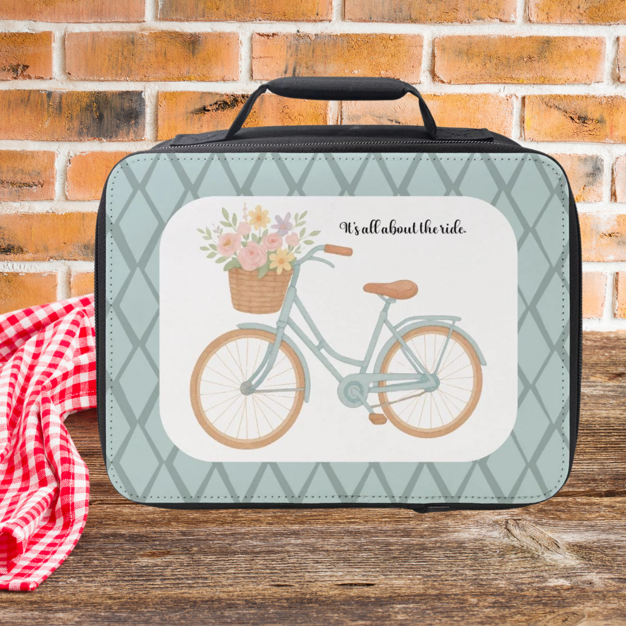  insulated lunch bag with bicycle and flowers design on a wooden surface with brick background
