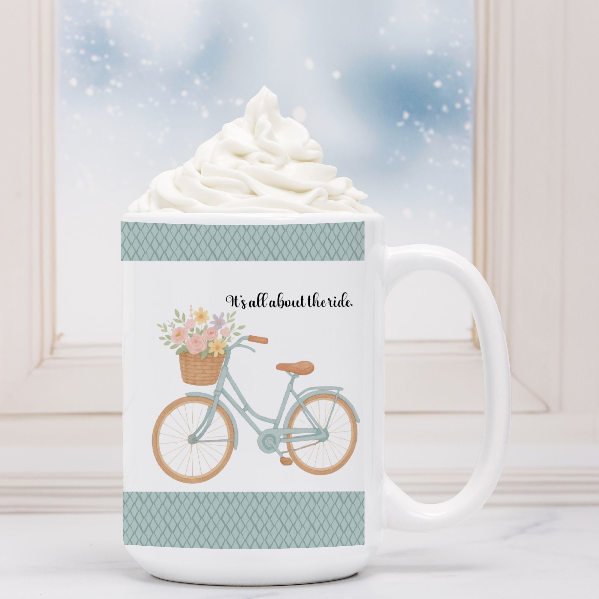 White mug with bicycle and floral design, filled with hot chocolate and whipped cream.
