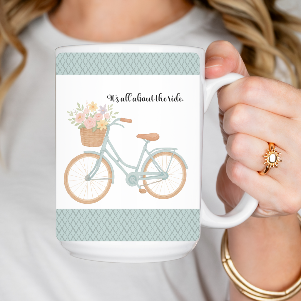 mug held by a person with a bicycle design with motivational text ' It's all about the ride'