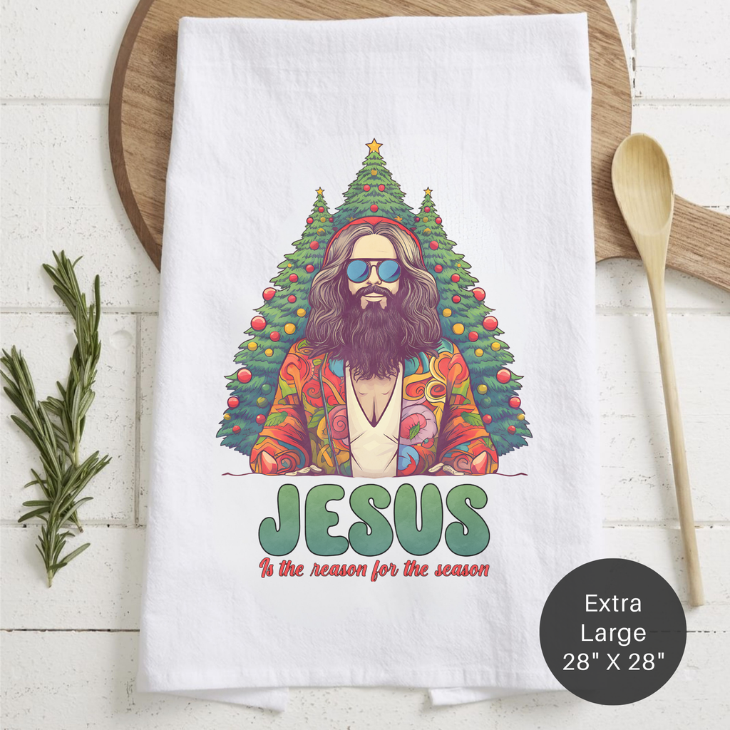 Tea towel with a colorful design of Jesus surrounded by Christmas trees on a wooden surface.