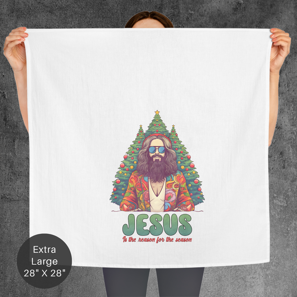 Person holding a towel with a colorful graphic of Jesus and a Christmas tree, with text 'Jesus is the reason for the season'.