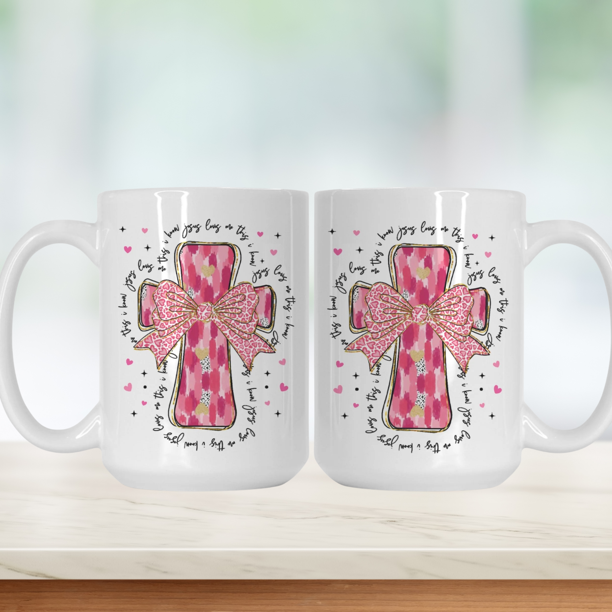 Two white mugs with pink cross designs and text on a white background