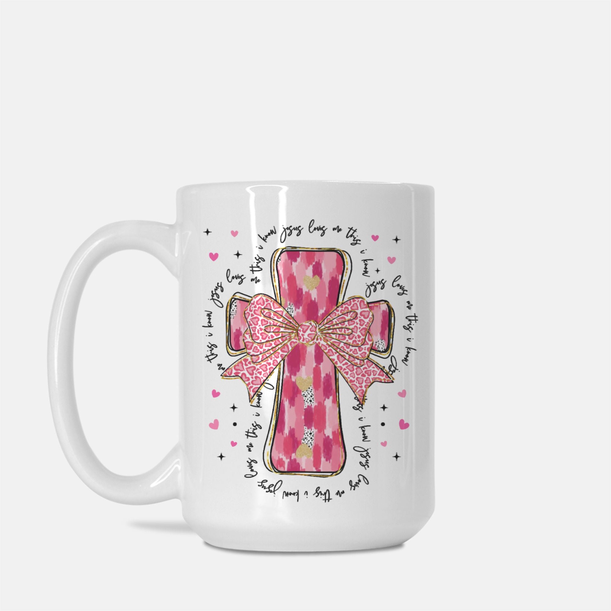 White mug with pink cross and bow design on a white background