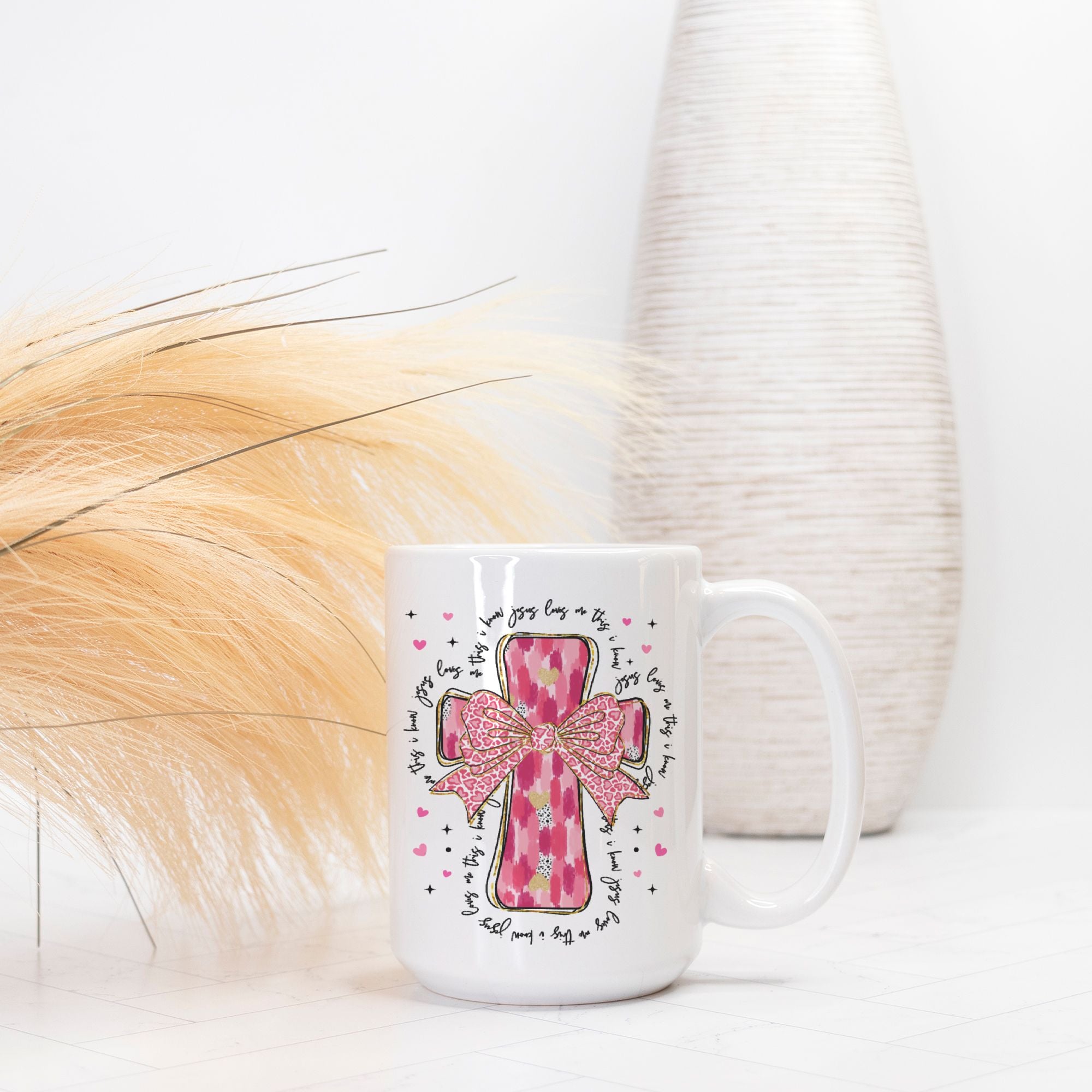 White mug with pink cross design on a white background
