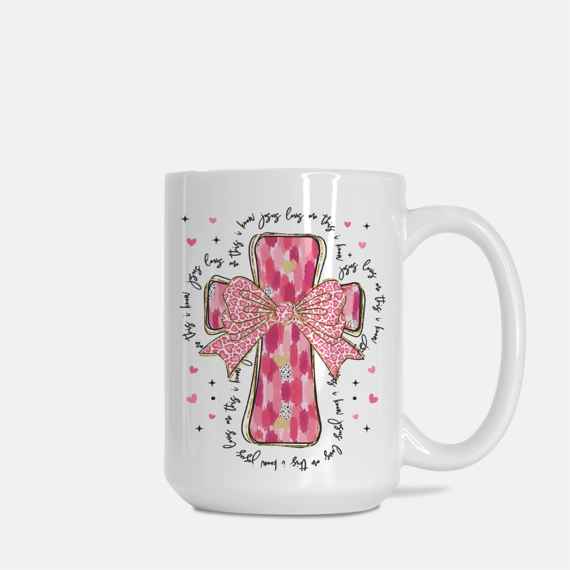 White mug with pink cross and bow design on a white background