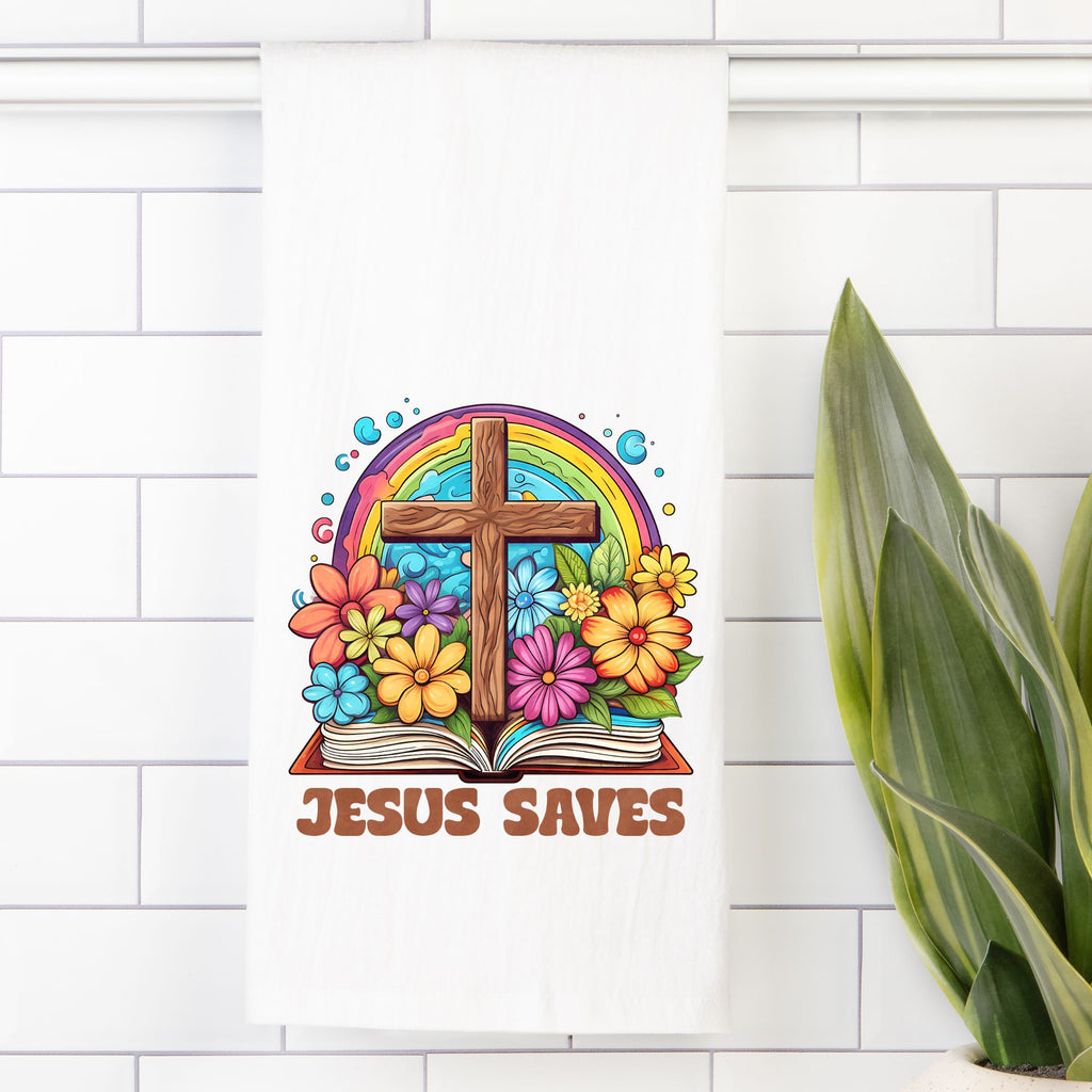 Colorful illustration of a cross, rainbow, and flowers on an tea towel with 'Jesus Saves' text against a white tiled wall.