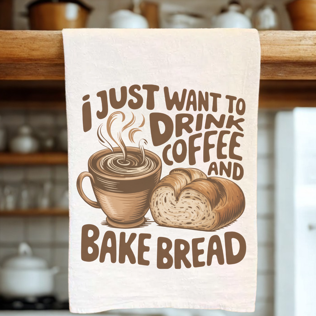 Kitchen towel with coffee cup and bread design, text 'I just want to drink coffee and bake bread' on a wooden rack.