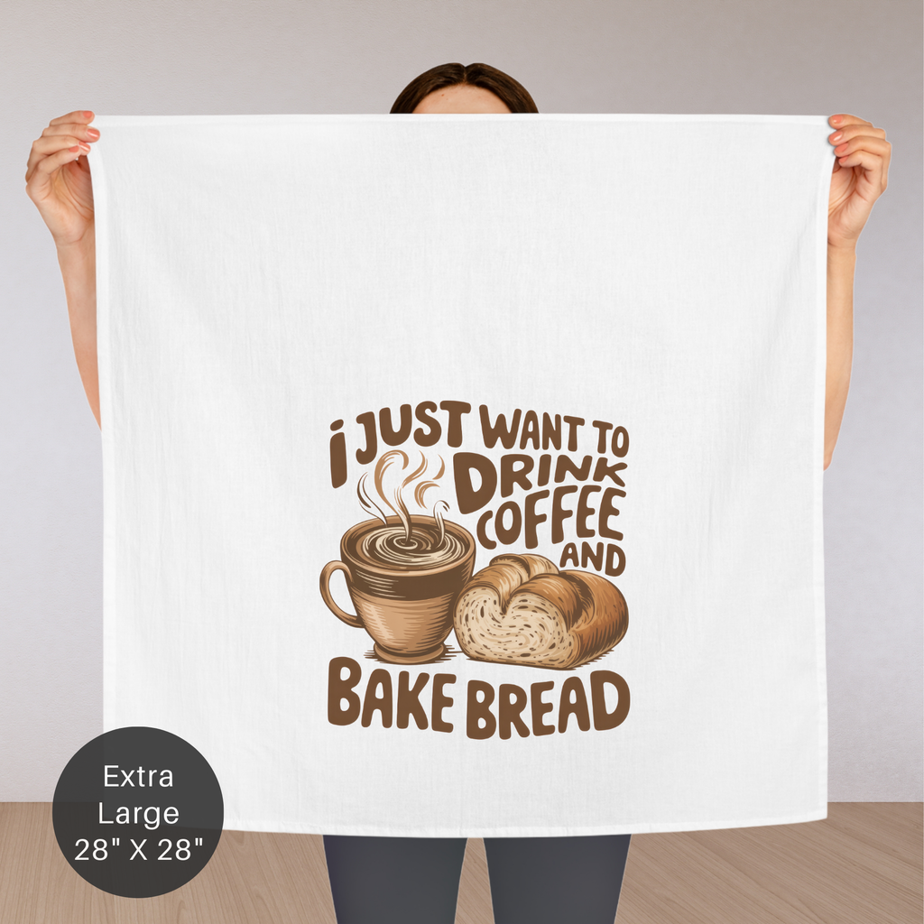 Person holding an extra large tea towel with coffee and bread design and text.