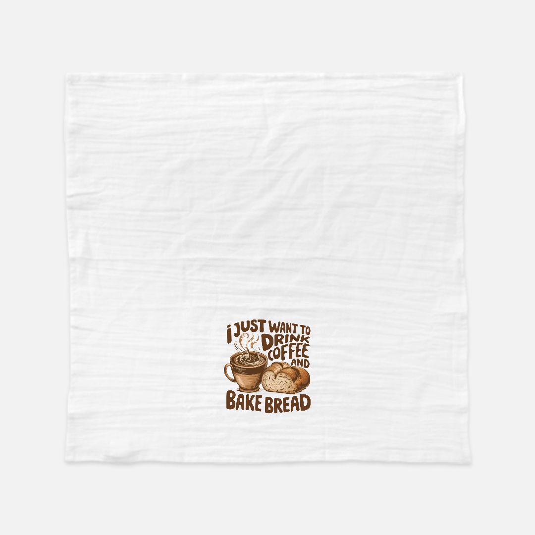 White tea towel with a graphic of a coffee cup and bread and text 'I just want to drink coffee and bake bread' on a white background.