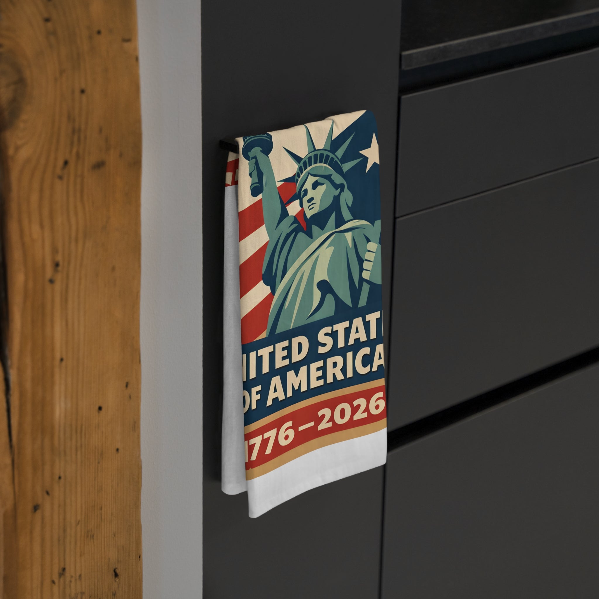 Tea towel with Statue of Liberty design and 'United States of America 1776-2026' text on a black surface.