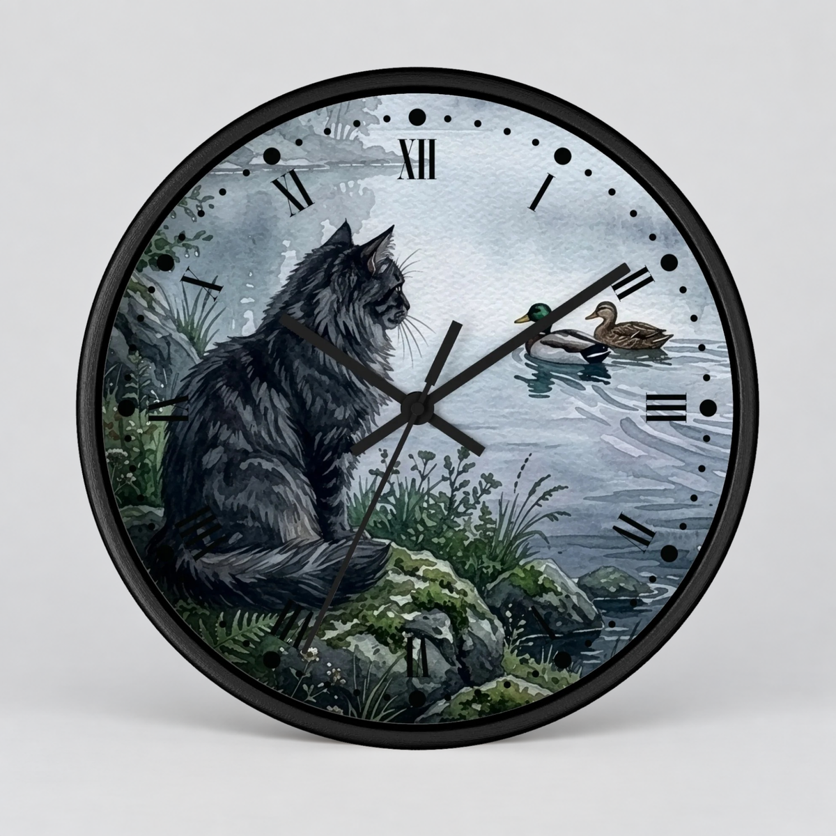 A round wall clock with a black frame and hands, featuring an illustrated scene of a large gray cat sitting by the water next to a mallard duck. The clock face has black Roman numerals and no hands except for the clock time.