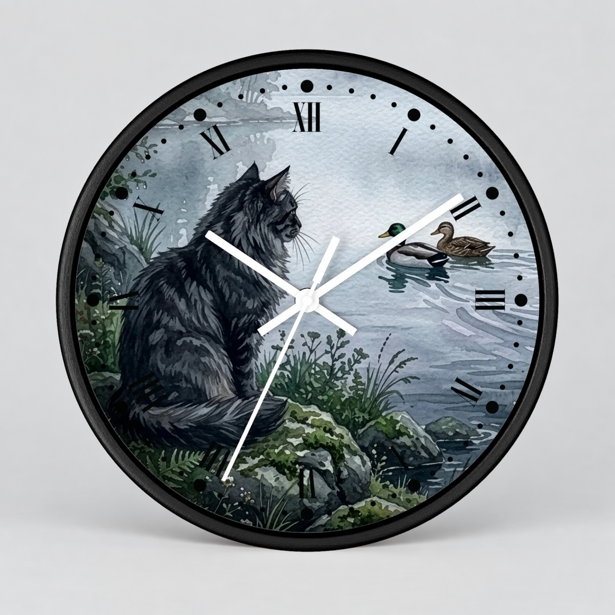 A round wall clock with a black frame and white hands, featuring an illustrated scene of a large black cat sitting by a lake with two ducks on the water. Roman numerals mark the hours, and the clock is shown against a light gray background.
