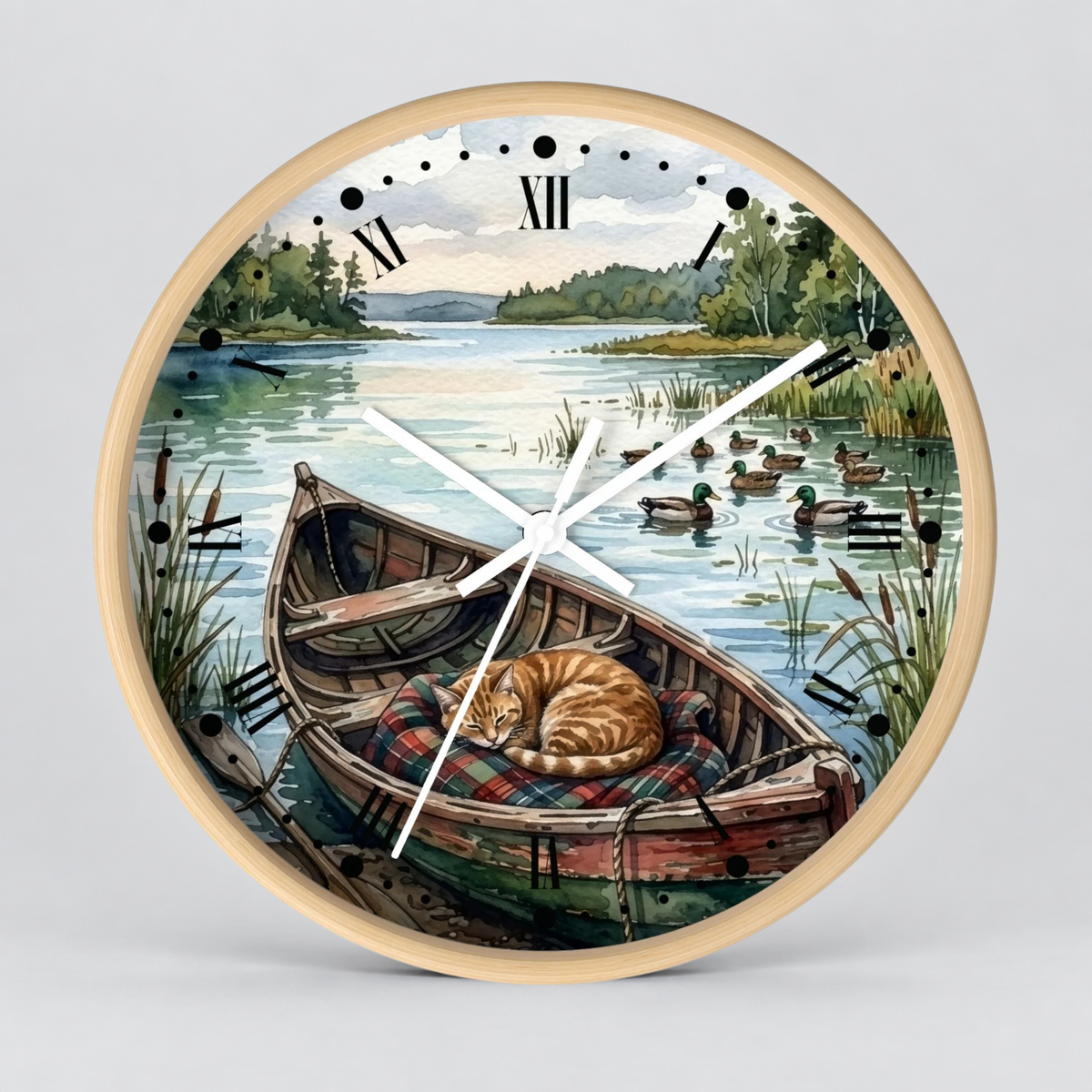 Round wall clock with a light wood frame and a scenic illustration of a cat sleeping in a wooden boat on a lake, with ducks and trees in the background. The clock face has black Roman numerals and white hands.