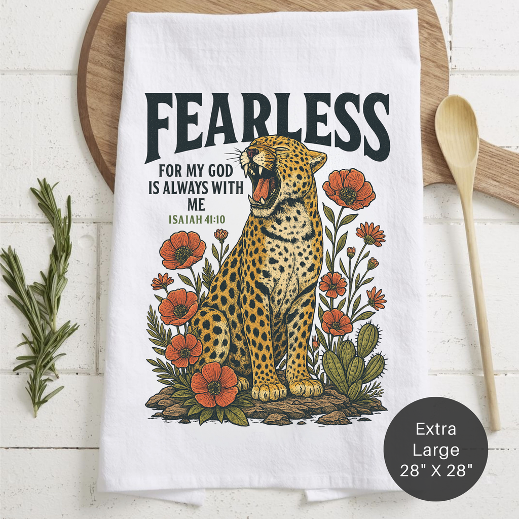Tea towel with a leopard illustration and 'Fearless' text on a wooden surface.