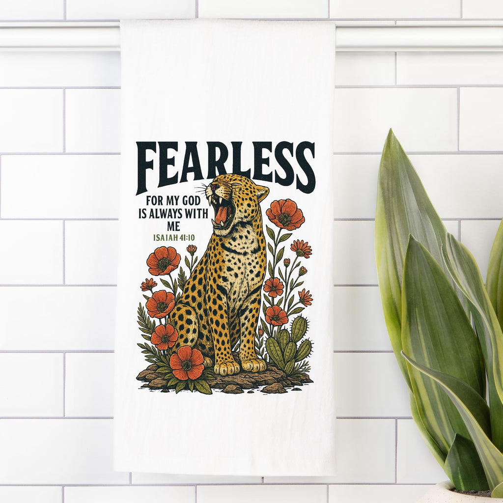 Tea towel with a Leopard illustration with flowers and 'Fearless' text on a white tiled wall.
