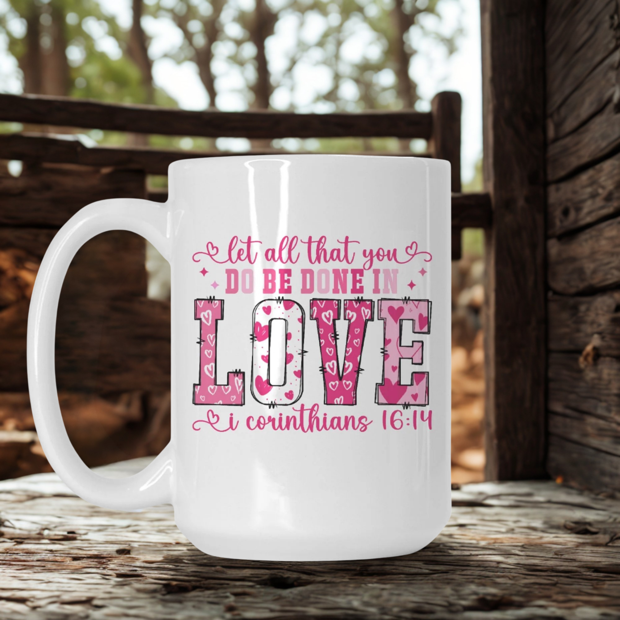 White mug with pink text on a wooden surface outdoors