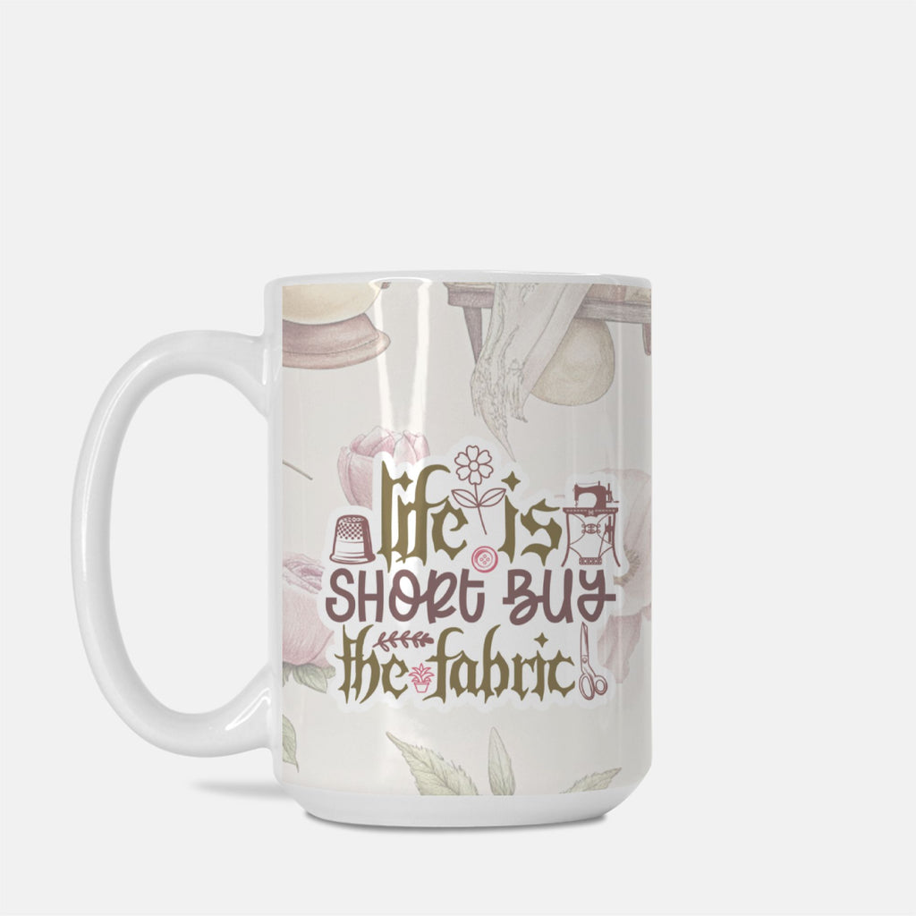 Mug with 'Life is short, buy the fabric' text and sewing-themed design on a white background
