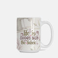 Mug with 'Life is short, buy the fabric' text and sewing-themed design on a white background