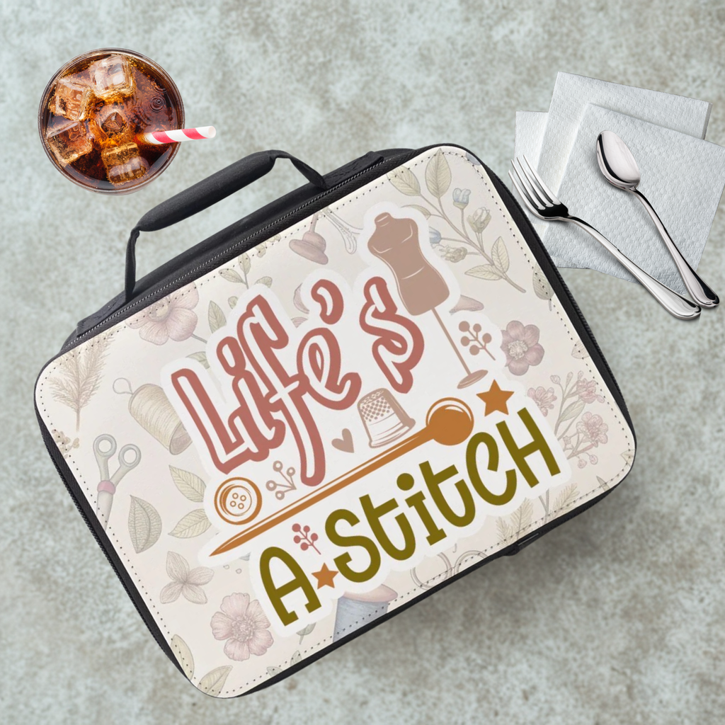 Lunch bag with 'Life's a Stitch' sewing themed design on a gray cafeteria table with a drink and utensils.
