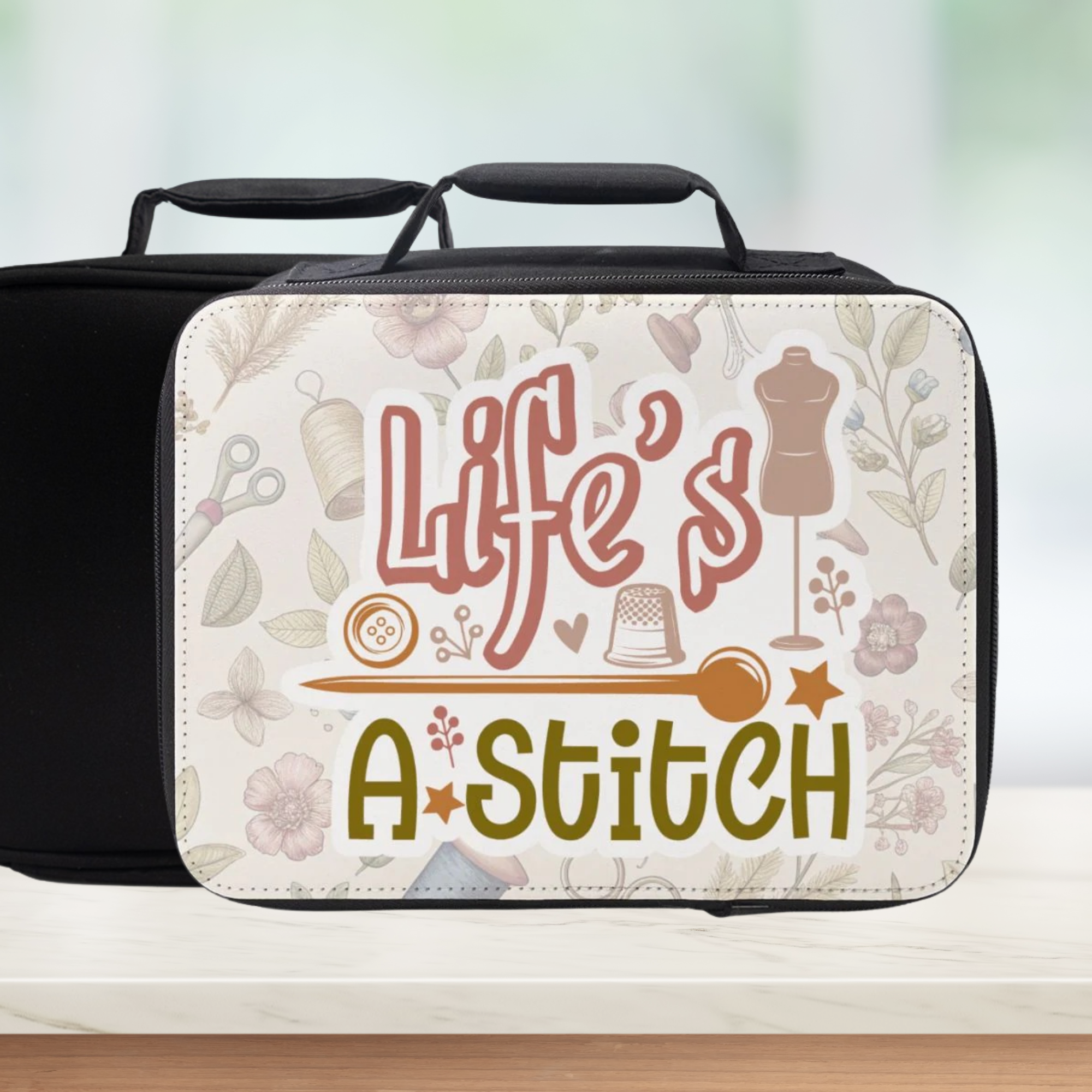 Black insulated lunch bag with 'Life's a Stitch' sewing themed design on a light background