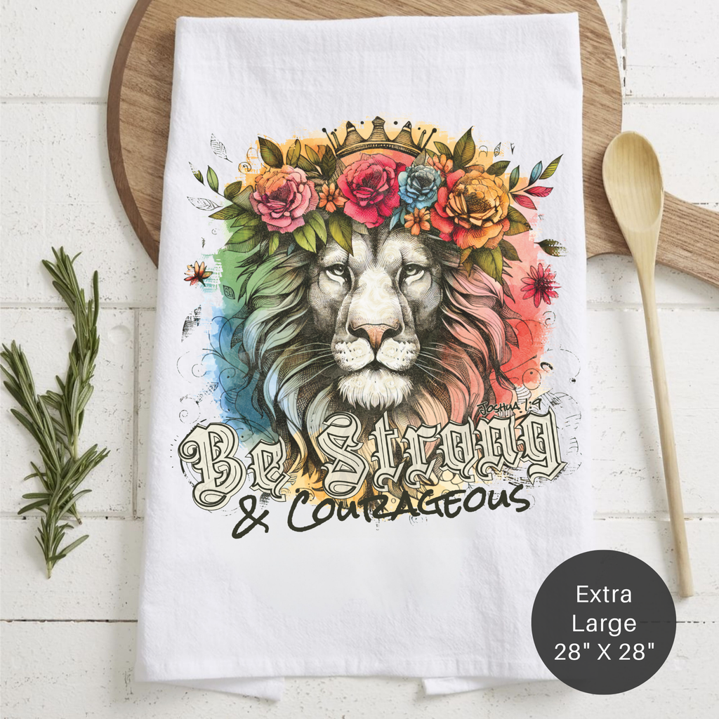 Tea towel with a lion design and motivational text on a wooden surface.