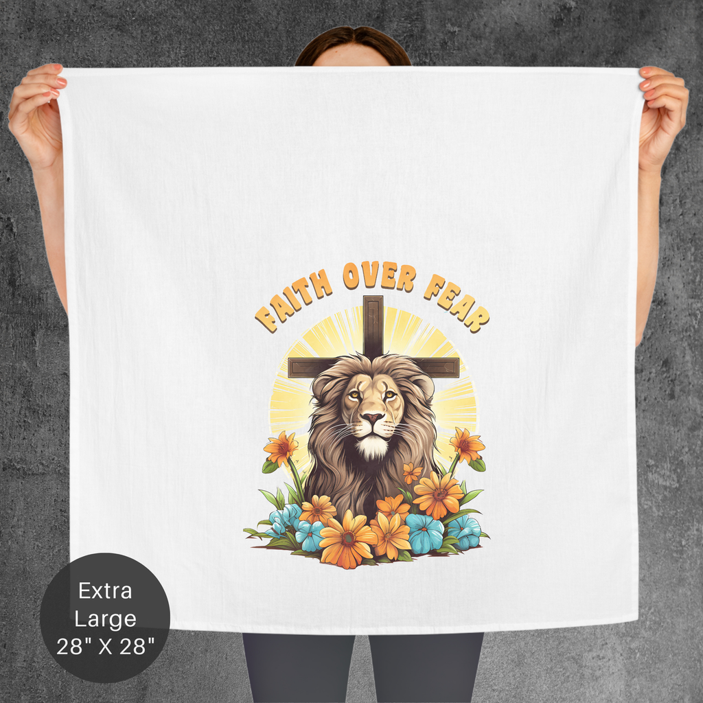 Person holding an extra large tea towel with a lion, cross, and 'Faith Over Fear' design.