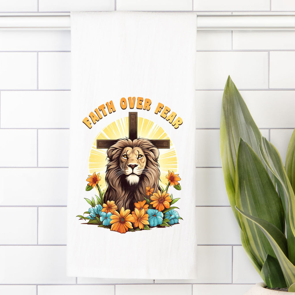 Decorative tea towel with a lion, cross, and 'Faith Over Fear' text on a white tiled wall.