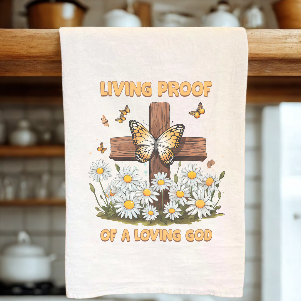 Tea Towel with a cross, butterfly, and flowers design on a wooden rack.