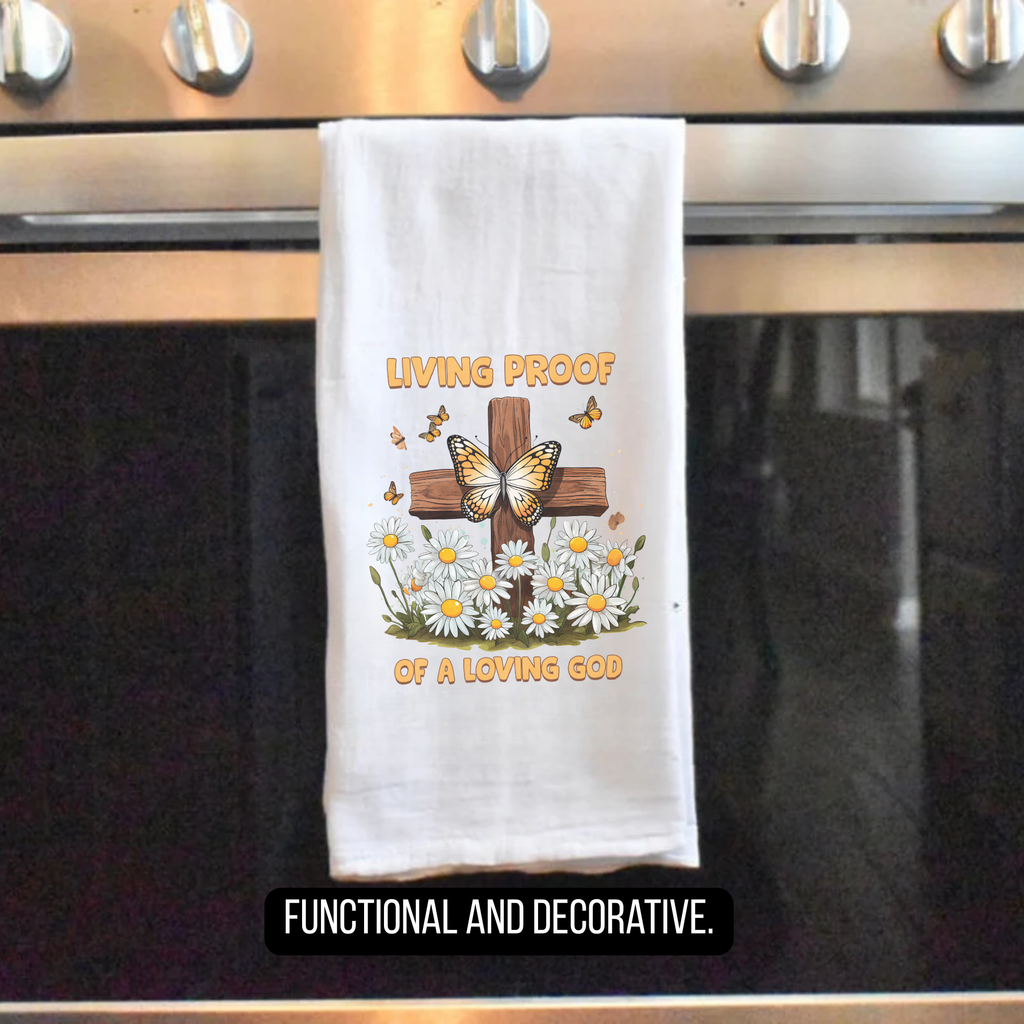 Decorative towel with cross and butterfly design hanging on a stove handle.