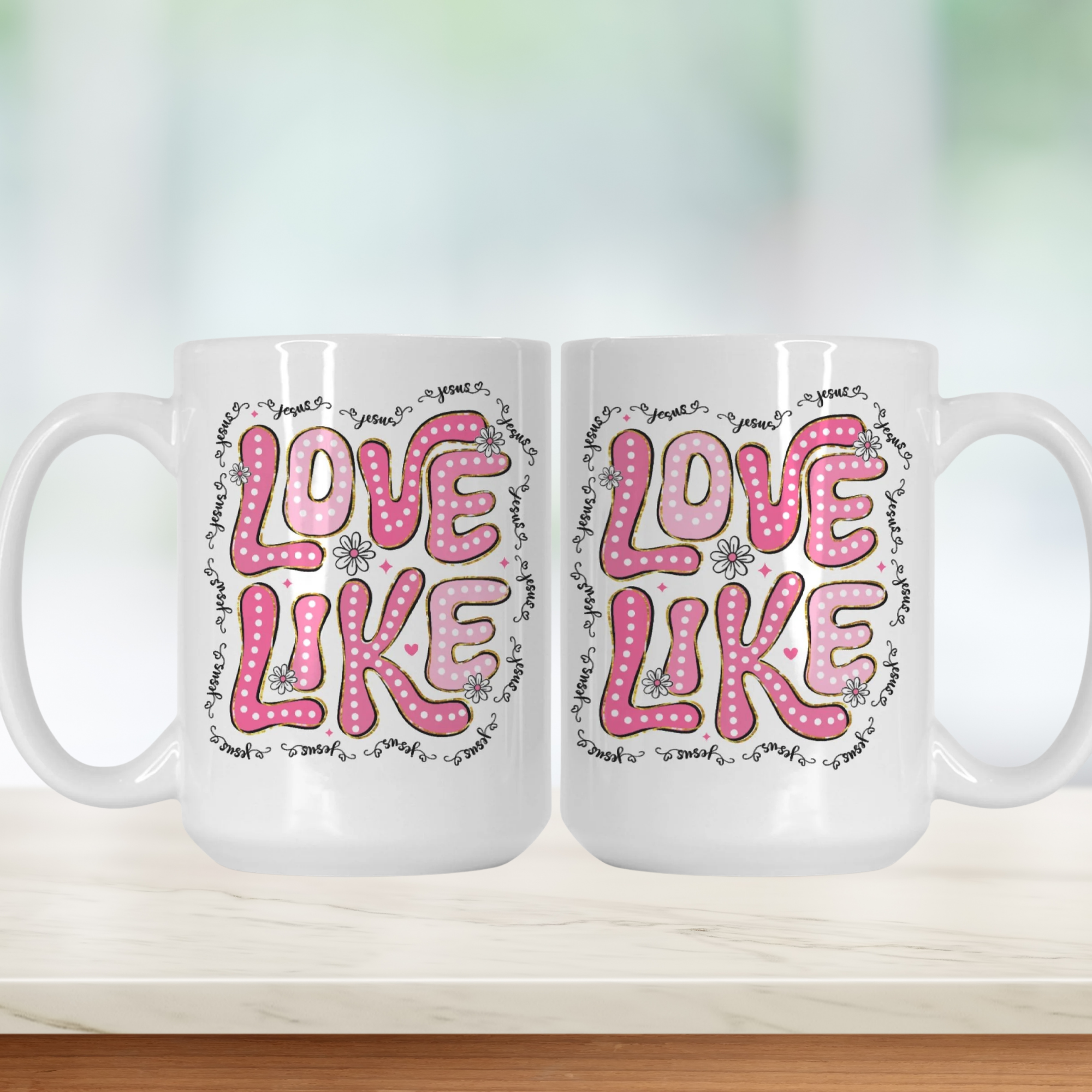 Two white mugs with pink 'LOVE LIKE' text on a wooden surface.