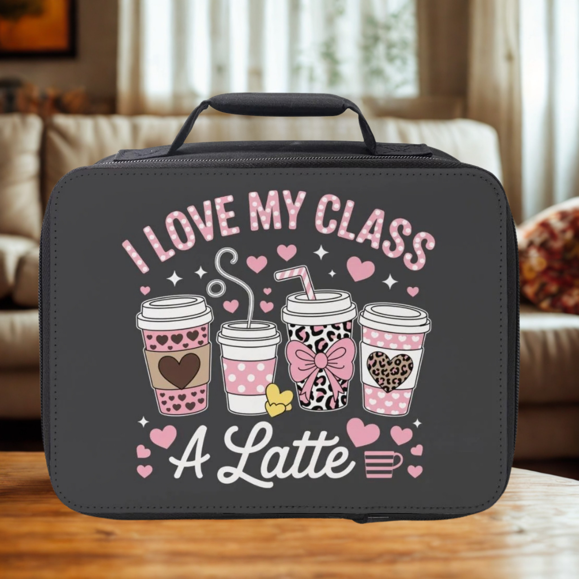 Black lunch bag with coffee cup graphics and text on a wooden living room table.