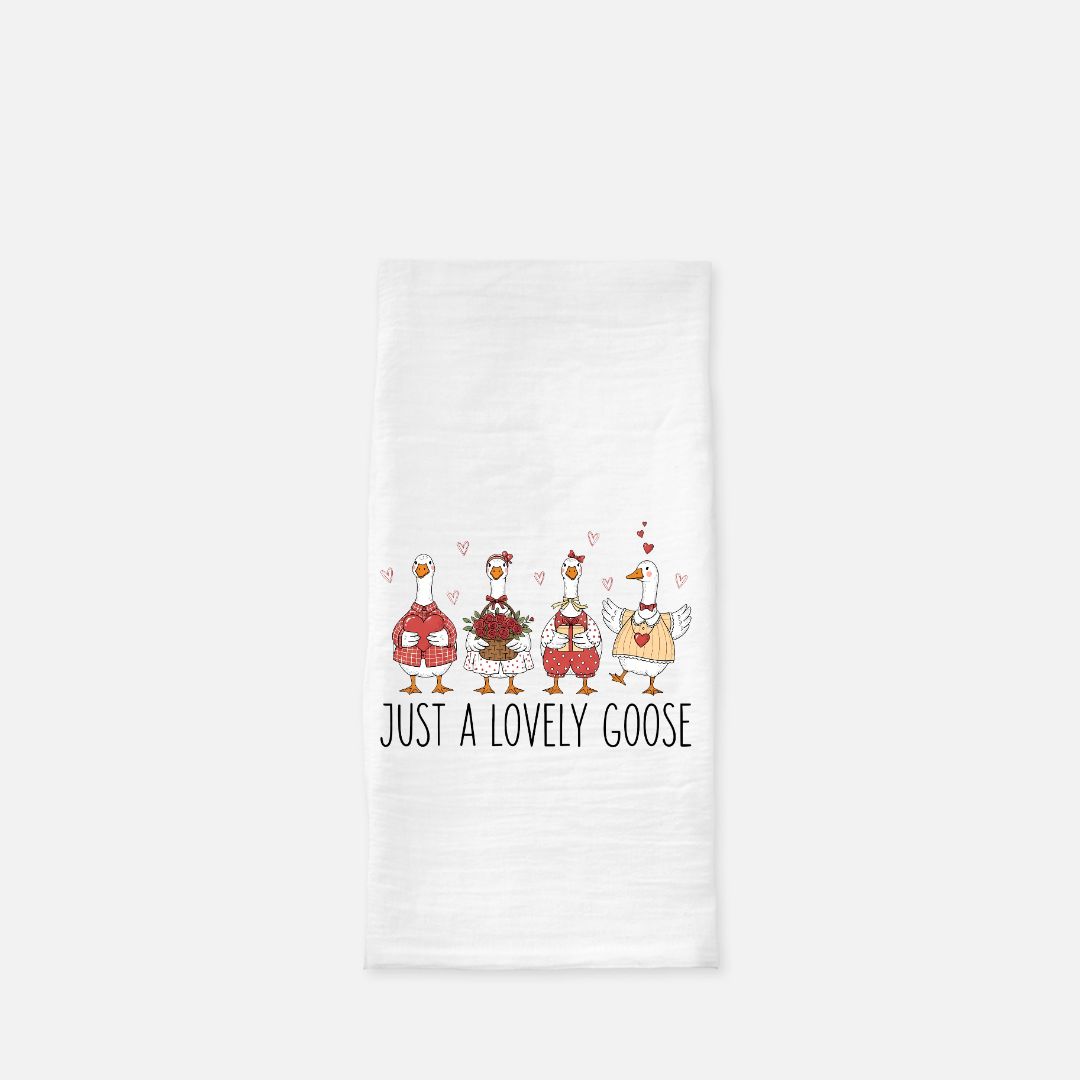 Tea towel with cartoon geese design and text 'Just a Lovely Goose' on a white background