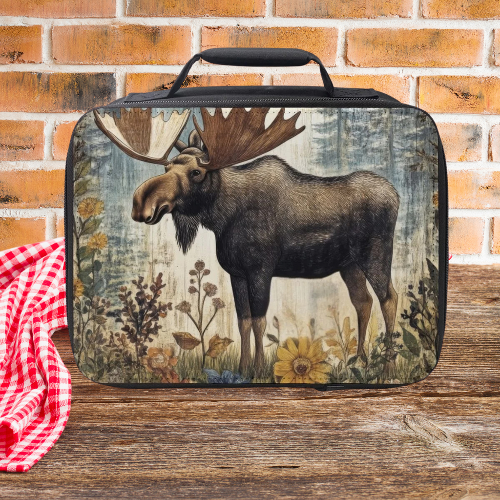  insulated lunch bag with moose design on a wooden picnic table and brick wall background