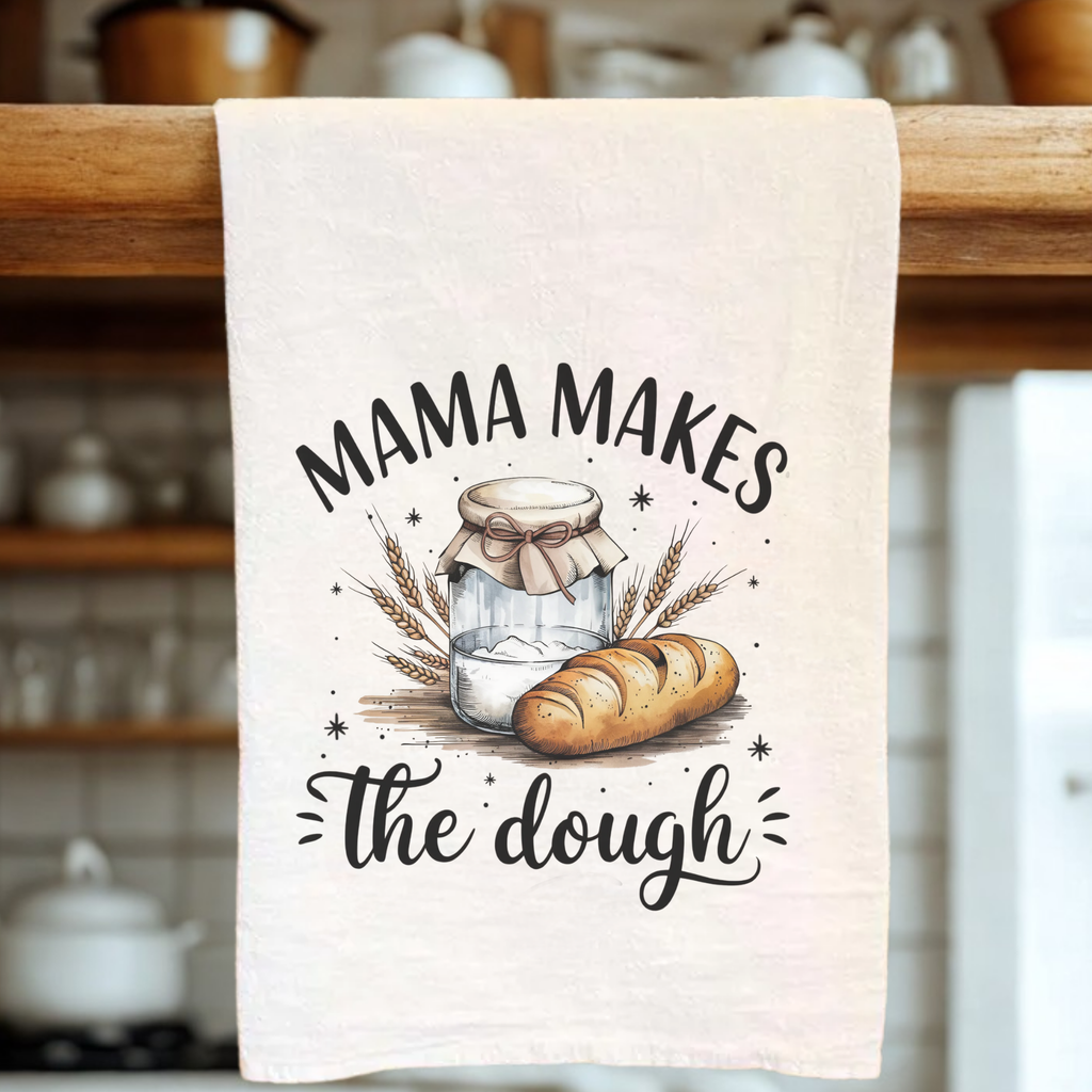 Kitchen towel with bread and jar design and 'Mama Makes the Dough' text on a wooden rack.