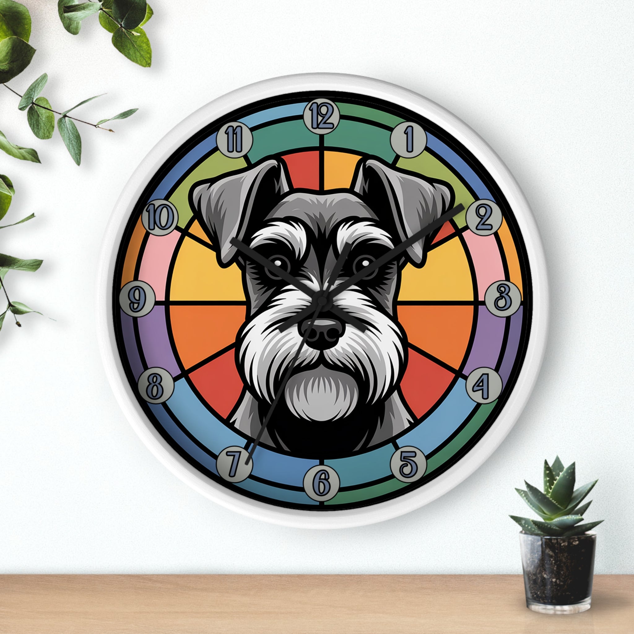 White wall clock with a schnauzer dog design on a colorful background, placed on a wooden surface with plants.