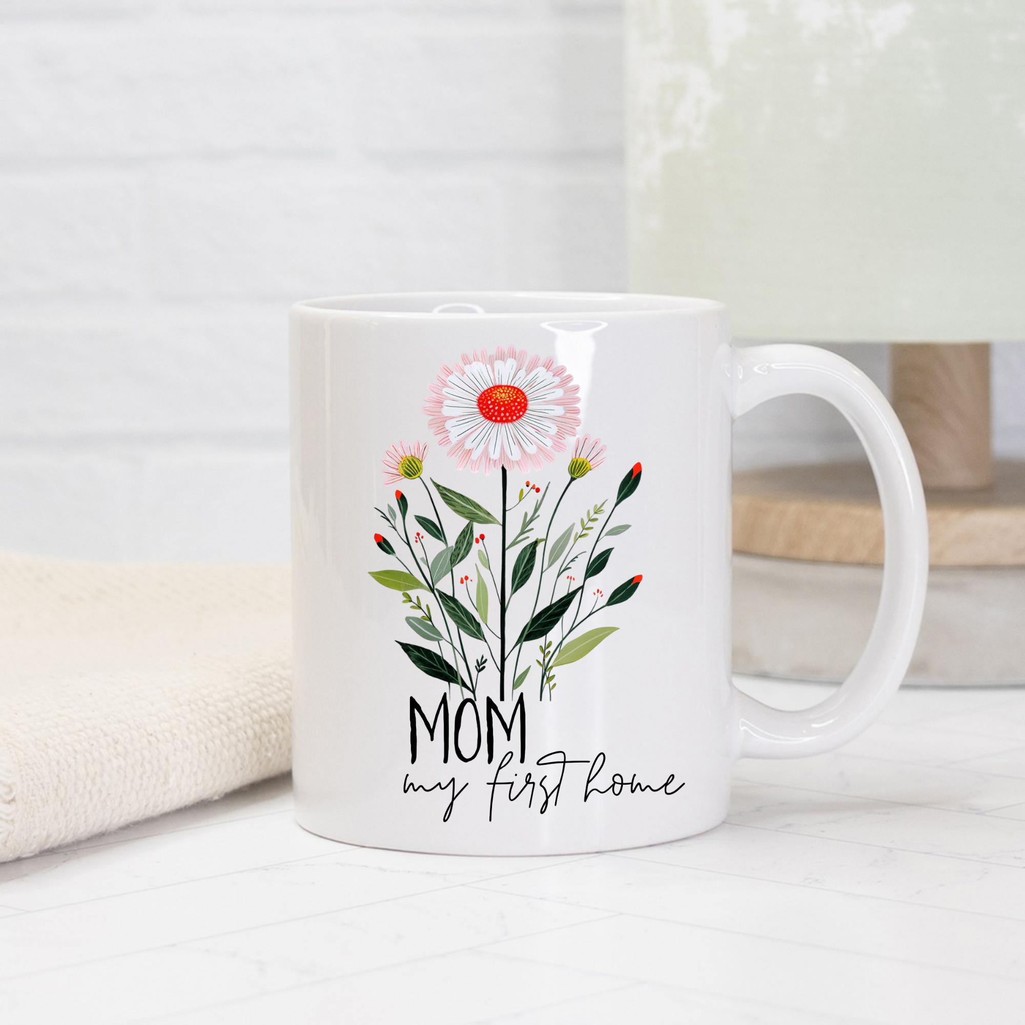 White 11oz mug with floral design and text 'Mom my first home' on a light background