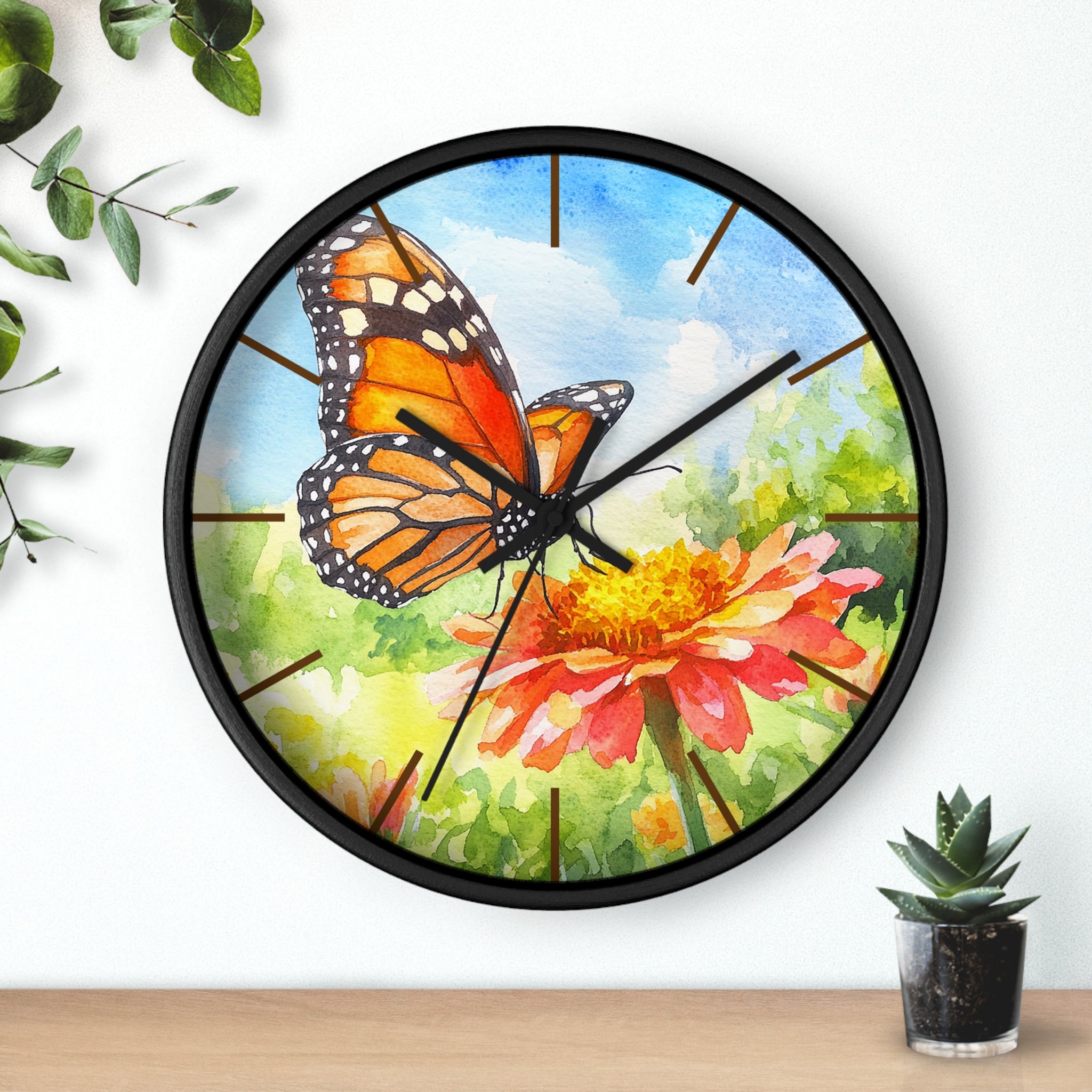 Black Wall clock with butterfly and flower design on a white background