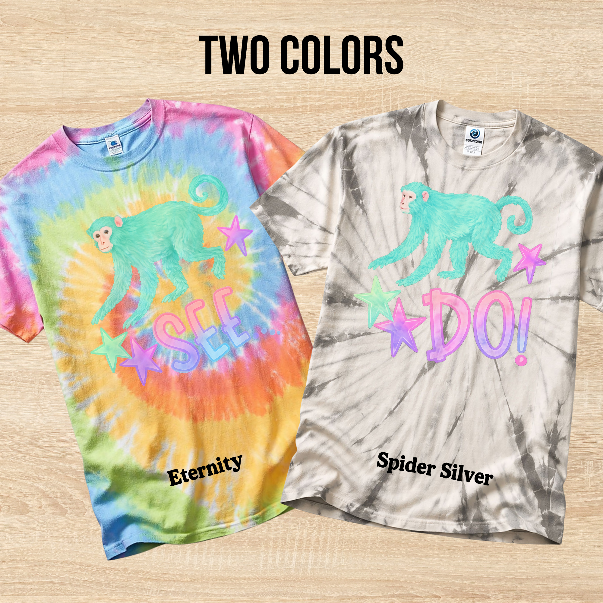 Two tie-dye t-shirts with a monkey graphic and text on a wooden surface.