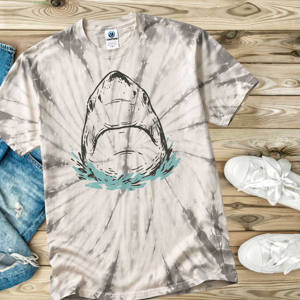 Tie-dye t-shirt in the color Spider Silver with a hand drawn shark design on a wooden surface with jeans and sneakers.
