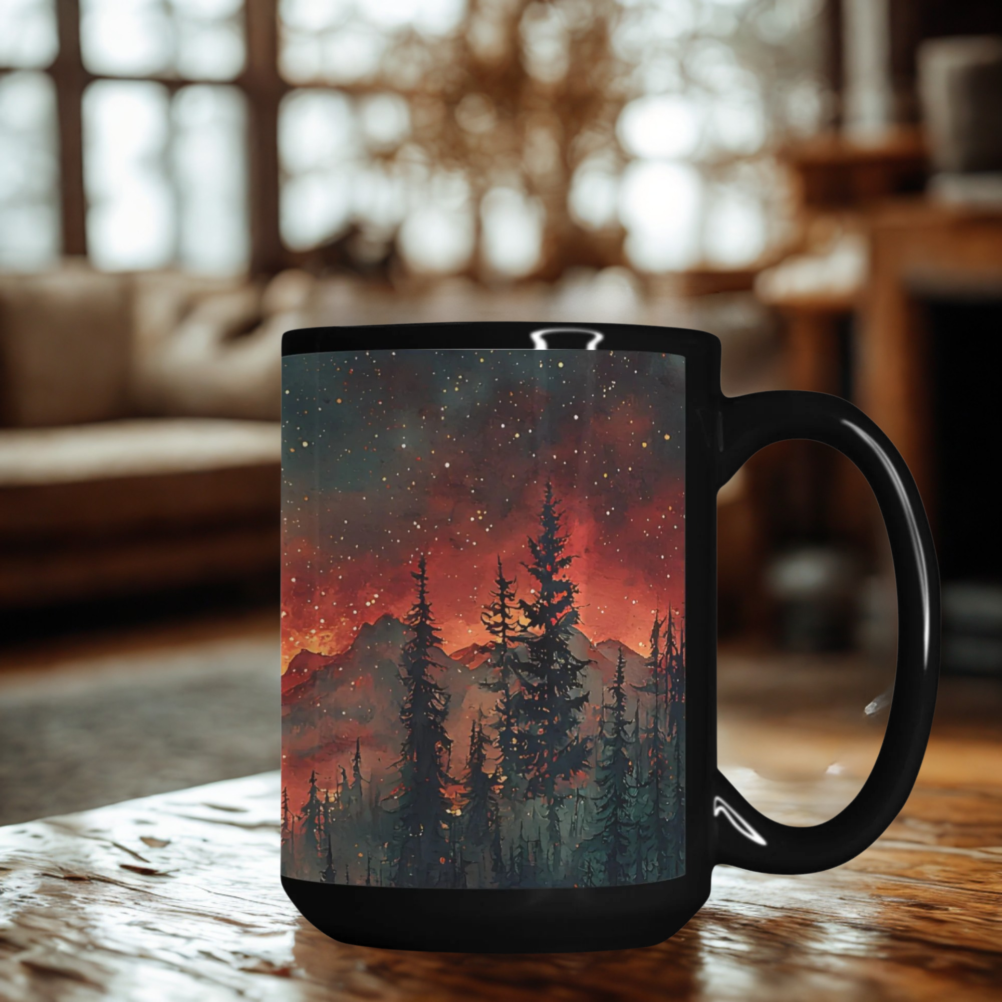 Black mug with a scenic design of trees and mountains on a wooden table in a cozy room.
