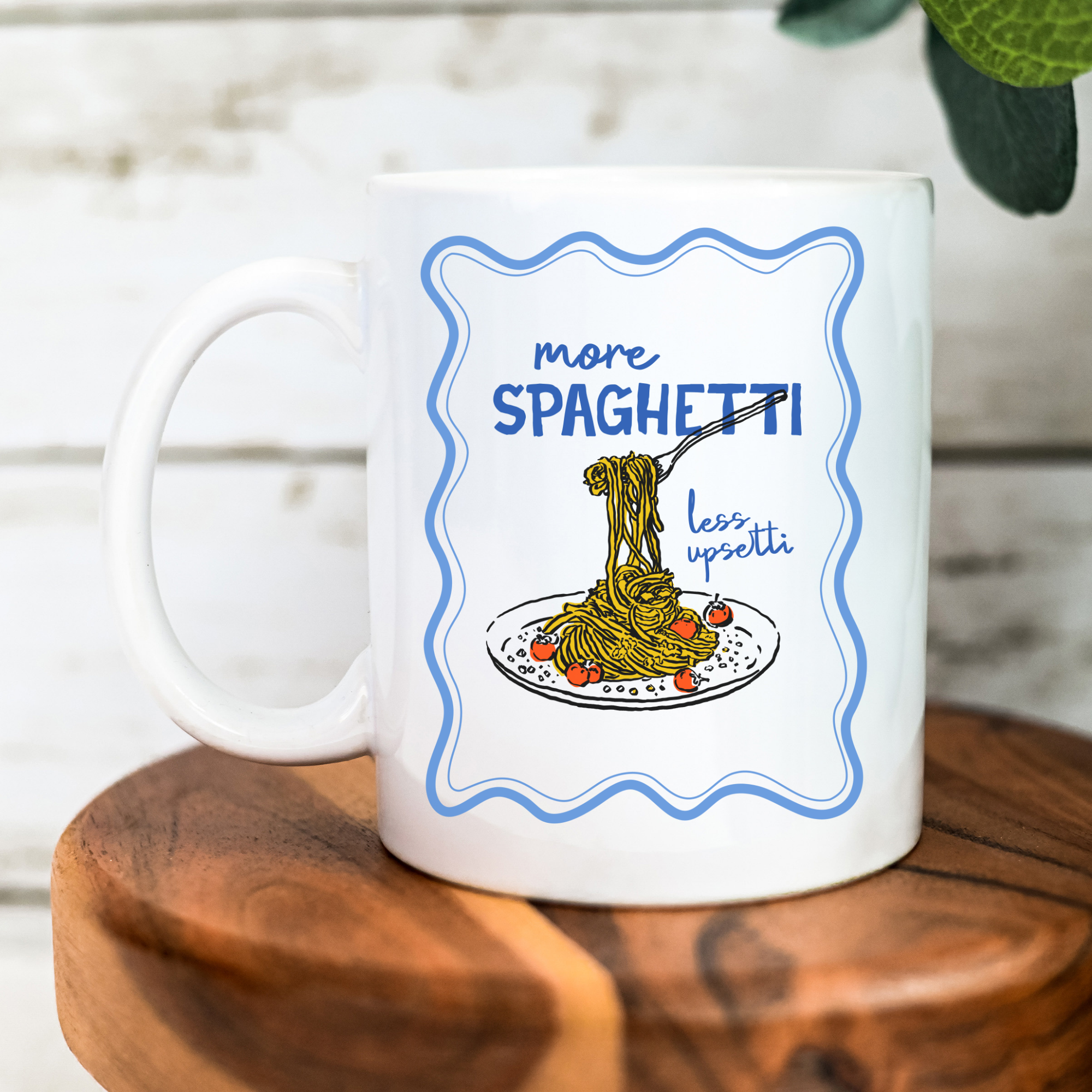 White 11oz. mug with spaghetti-themed design on a wooden surface