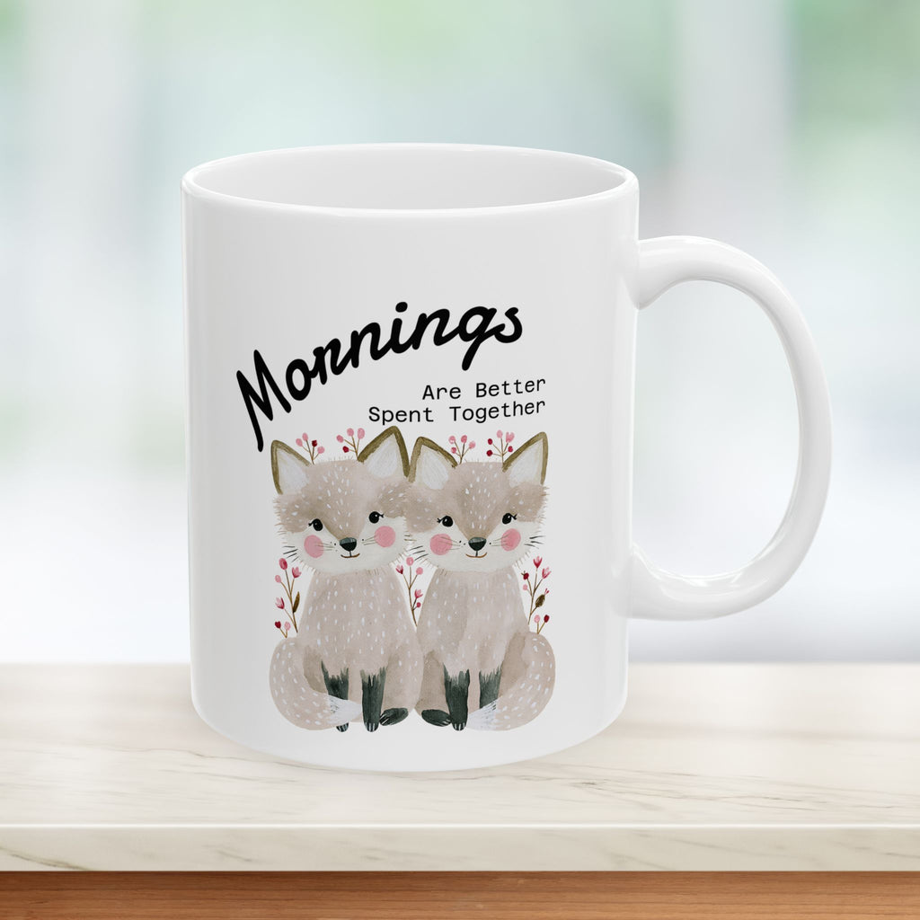 11oz ceramic mug with a fox couple design on a counter with a green background.