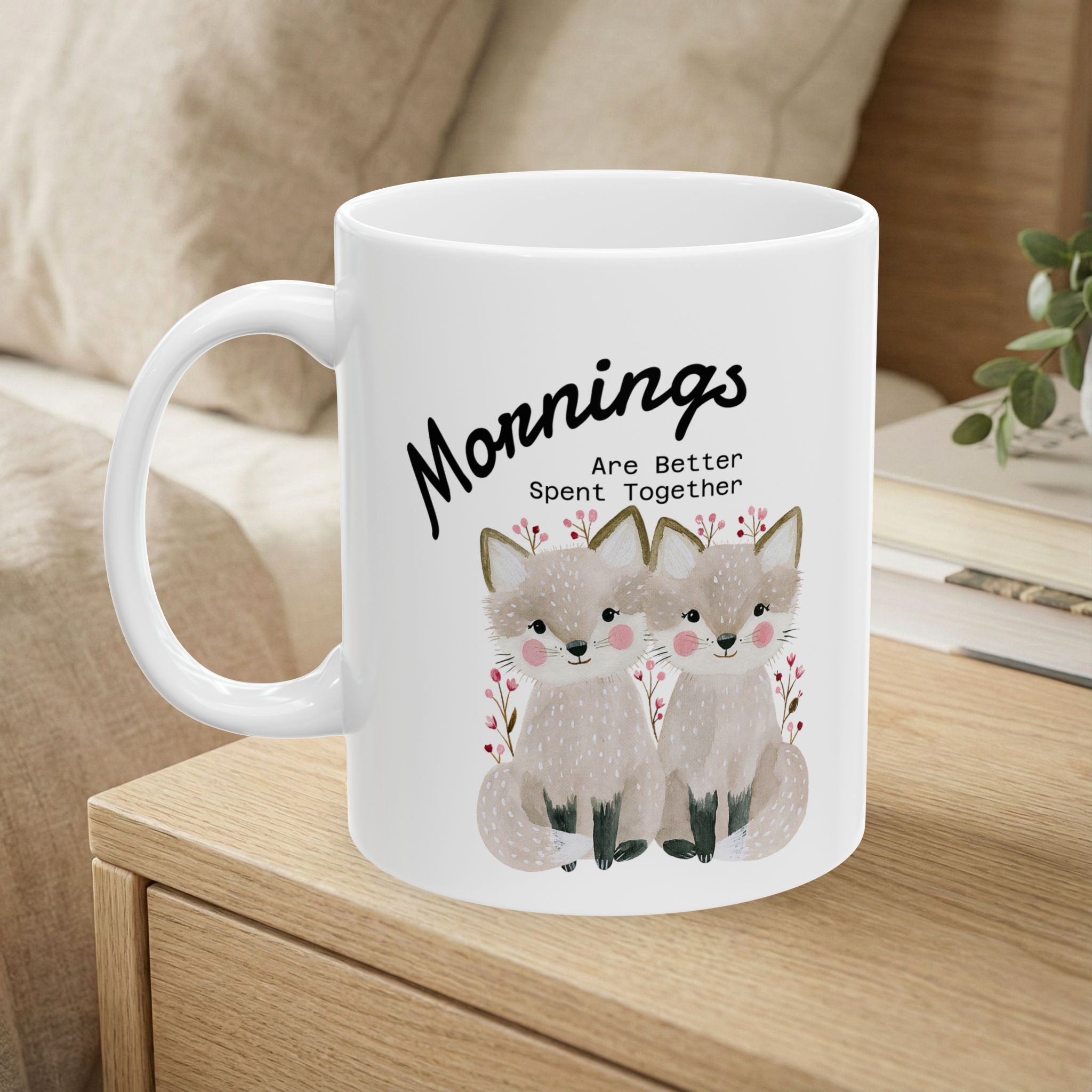 11oz ceramic mug with a fox couple design sitting on a bedside table.