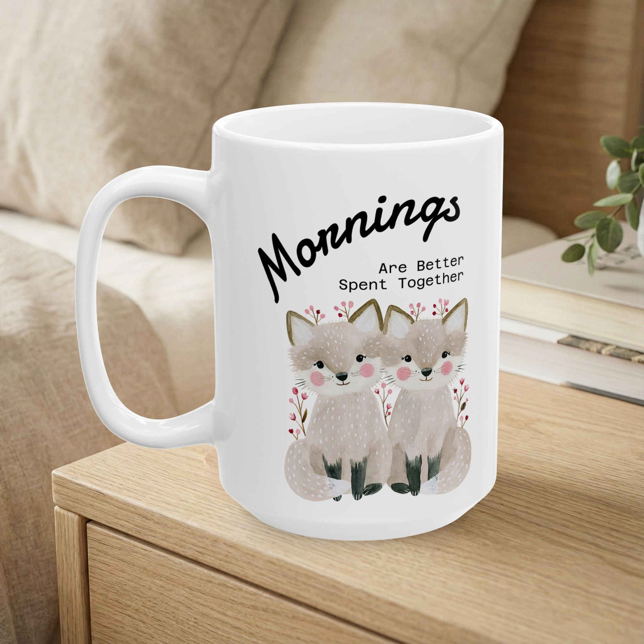 15oz ceramic mug with a fox couple design sitting on a bedside table.